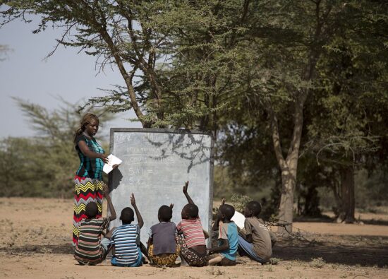 African teacher teaching under a tree.jpg